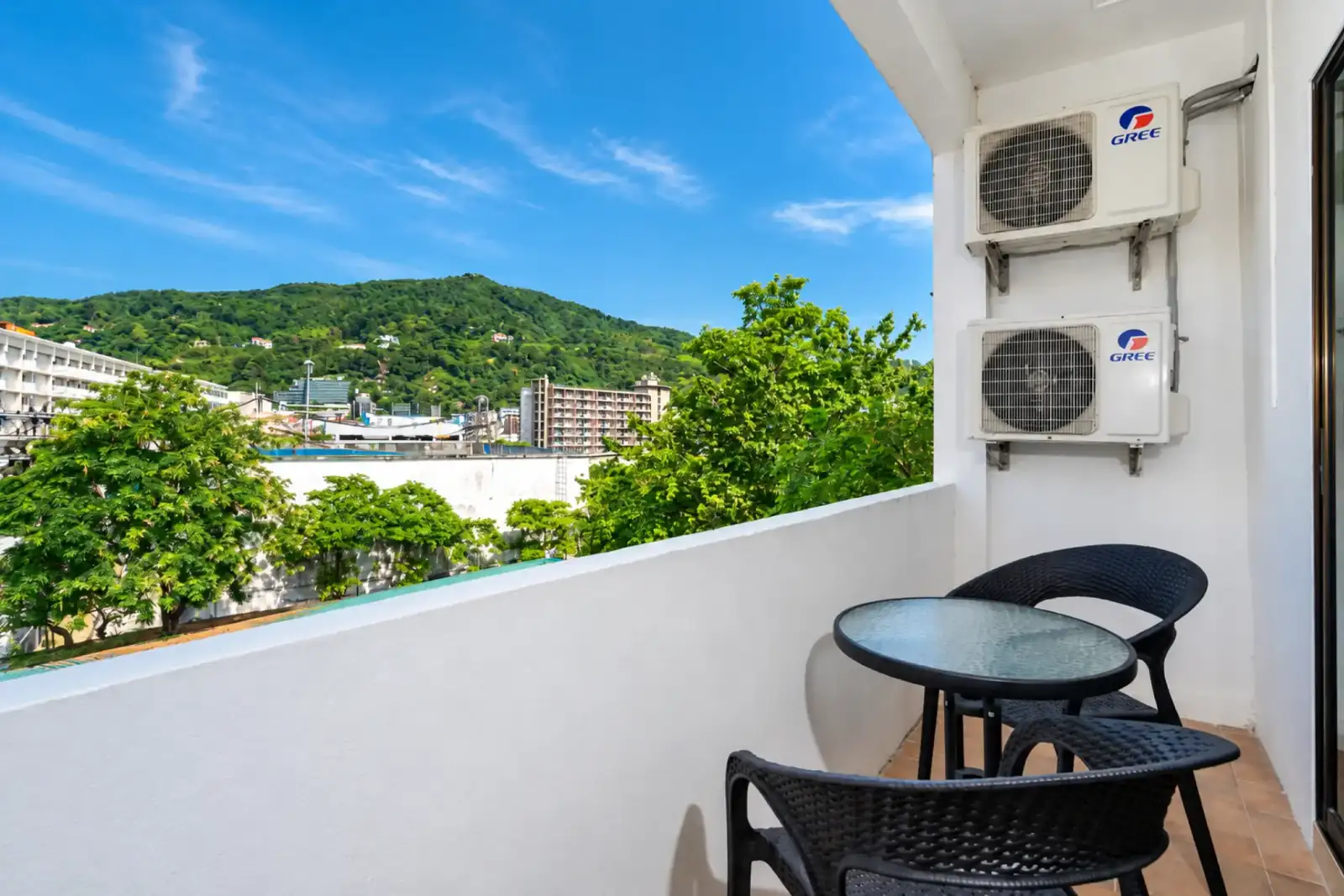 ที่นั่งริมระเบียงมองเห็นเนินเขาเขียวขจีของป่าตองที่ Black Pantera Hostel